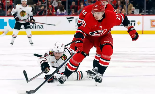 Carolina Hurricanes' Alexander Nikishin takes the puck away from Chicago Blackhawks' Ryan Donato (8) during the first period of an NHL hockey game in Raleigh, N.C., Thursday, Jan. 22, 2026. (AP Photo/Karl DeBlaker)