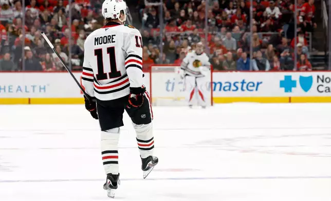 Chicago Blackhawks' Oliver Moore (11) celebrates after his winning shootout goal against the Carolina Hurricanes in an NHL hockey game in Raleigh, N.C., Thursday, Jan. 22, 2026. (AP Photo/Karl DeBlaker)
