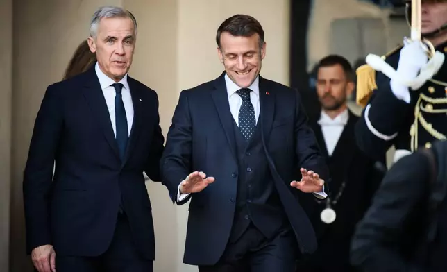 French President Emmanuel Macron, right, gestures as Canada's Prime Minister Mark Carney leaves the Elysee Palace in Paris, France, Tuesday, Jan. 6, 2026. (AP Photo/Thomas Padilla)