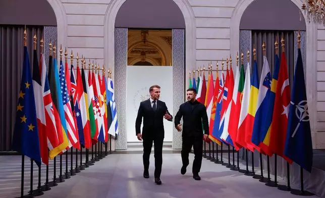 French President Emmanuel Macron, left, and Ukraine's President Volodymyr Zelenskyy arrive for a meeting of the Coalition of the Willing meeting at the Elysee Palace in Paris, France, Tuesday, Jan.6, 2026. (Yoan Valat, Pool photo via AP)