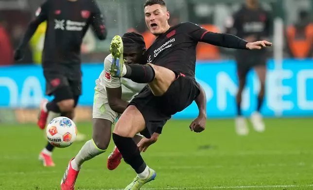 Leverkusen's Patrik Schick challenges for the ball with Bremen's Karim Coulibaly during the German Bundesliga soccer match between Bayer Leverkusen and Werder Bremen in Leverkusen, Germany, Saturday, Jan. 24, 2026. (AP Photo/Martin Meissner)