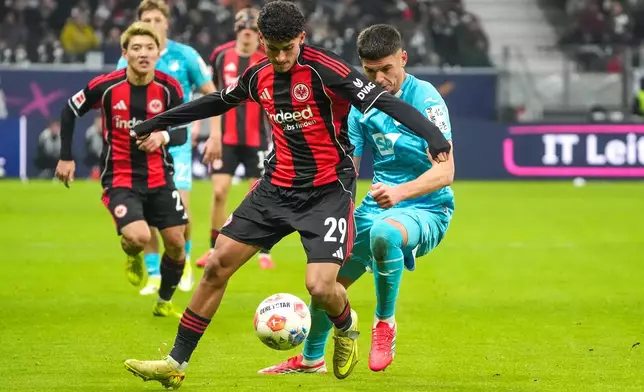 Frankfurt's Ayoube Amaimouni-Echghouyab, front, in a duel with Hoffenheim's Albian Hajdari during the German Bundesliga soccer match between Eintracht Frankfurt and Hoffenheim in Frankfurt, Saturday, Jan. 24, 2026. (Marc Schüler/dpa via AP)