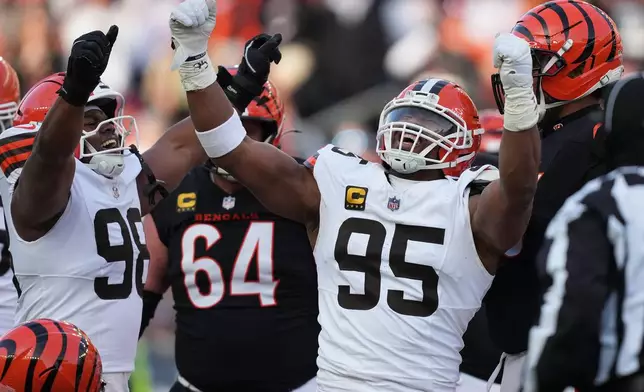 Cleveland Browns defensive end Myles Garrett (95) celebrates with defensive end Adin Huntington (98) after sacking Cincinnati Bengals quarterback Joe Burrow to set an NFL record for sacks in the regular season during the second half of an NFL football game, Sunday, Jan. 4, 2026, in Cincinnati. (AP Photo/Joshua A. Bickel)