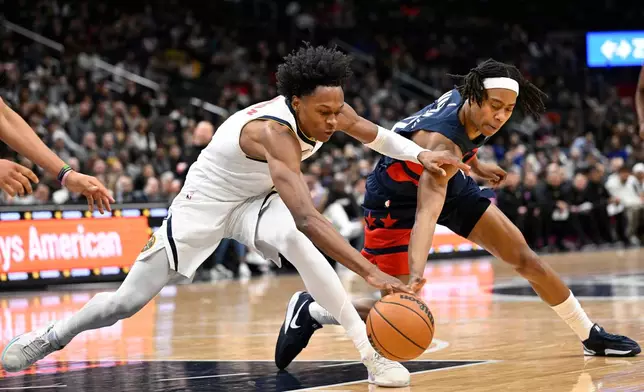 Denver Nuggets guard Peyton Watson, left, and Washington Wizards guard Tre Johnson compete for a loose ball during the second half of an NBA basketball game, Thursday, Jan. 22, 2026, in Washington. (AP Photo/John McDonnell)