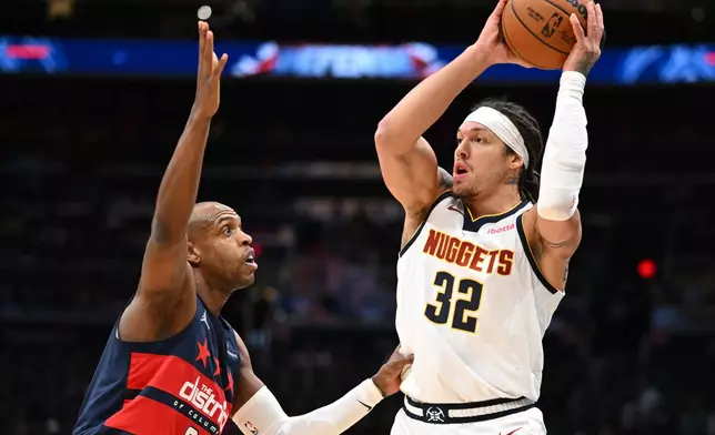 Washington Wizards forward Khris Middleton, left, guards Denver Nuggets forward Aaron Gordon (32) during the first half of an NBA basketball game, Thursday, Jan. 22, 2026, in Washington. (AP Photo/John McDonnell)