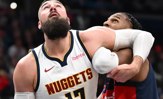 Denver Nuggets center Jonas Valanciunas, left, and Washington Wizards center Alex Sarr, right, compete for a rebound during the first half of an NBA basketball game, Thursday, Jan. 22, 2026, in Washington. (AP Photo/John McDonnell)