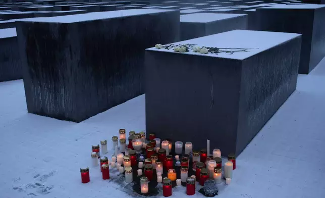 Candles placed in front of a concrete slab of the Holocaust memorial to mark the International Holocaust Memorial Day in Berlin, Germany, Tuesday, Jan. 27, 2026. (AP Photo/Markus Schreiber)