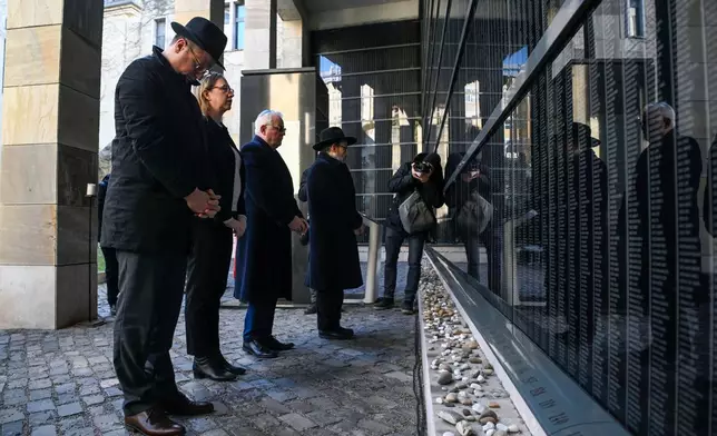 From left, Hungarian Minister heading the Prime Minister's Office Gergely Gulyas, Israel's ambassador to Hungary Maya Kadosh, President of the Federation of Jewish Communities in Hungary (Mazsihisz) Andor Grosz and Hungarian Hasidic Jewish religious leader and head of the Hungarian Chabad-Lubavitch movement rabbi Baruch Oberlander stand at the Victims' Wall during a memorial service in the Holocaust Memorial Centre in Budapest, Hungary, Tuesday, January 27, 2026, on International Holocaust Remembrance Day. (Tamas Purger/MTI via AP)