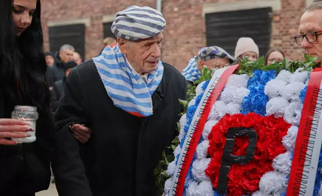 Holocaust survivor Stanislaw Zalewski walks in the Auschwitz Nazi death camp museum during a ceremony marking the 81th anniversary of the camp's liberation in Oswiecim, Poland, Tuesday, Jan. 27, 2026. (AP Photo/Beata Zawrzel)