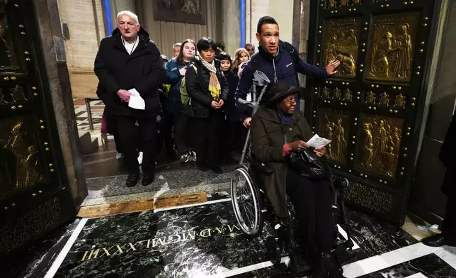 Natalie Turner and her son Phillip cross the Holy Door in St.Peter's Basilica at the Vatican on the last day of its public opening, Monday, Jan. 5, 2026. (AP Photo/Alessandra Tarantino)