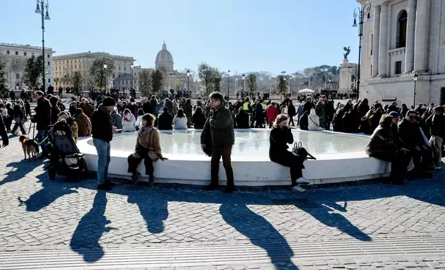 FILE - People sit on a fountain after the inauguration of the new design of Piazza Pia, a pedestrian piazza at the end of the Via della Conciliazione boulevard, opposite St. Peter's Basilica, Thursday, Dec. 26, 2024. (Mauro Scrobogna/LaPresse via AP, file)