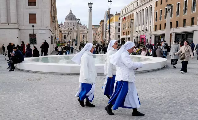 FILE - Nuns walk past a fountain after the inauguration of the new design of Piazza Pia, a pedestrian piazza at the end of the Via della Conciliazione boulevard, opposite St. Peter's Basilica, Thursday, Dec. 26, 2024. (Mauro Scrobogna/LaPresse via AP, file)