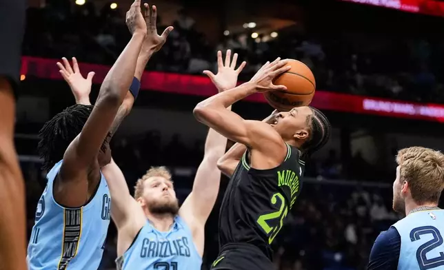 New Orleans Pelicans forward Trey Murphy III (25) shoots against Memphis Grizzlies center Jock Landale (31) and forward GG Jackson in the first half of an NBA basketball game, Friday, Jan. 30, 2026, in New Orleans. (AP Photo/Gerald Herbert)