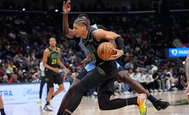 New Orleans Pelicans guard Jeremiah Fears (0) drives to the basket against Memphis Grizzlies guard Vince Williams Jr. in the first half of an NBA basketball game, Friday, Jan. 30, 2026, in New Orleans. (AP Photo/Gerald Herbert)