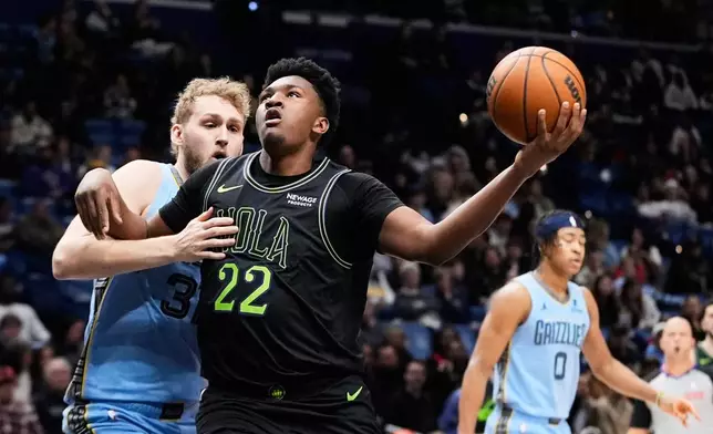New Orleans Pelicans center Derik Queen (22) drives to the basket against Memphis Grizzlies center Jock Landale in the first half of an NBA basketball game, Friday, Jan. 30, 2026, in New Orleans. (AP Photo/Gerald Herbert)