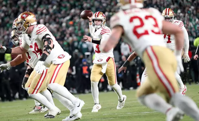 San Francisco 49ers' Brock Purdy, center, throws to Christian McCaffrey in the fourth quarter of an NFL wild-card playoff football game against the Philadelphia Eagles in Philadelphia, Sunday, Jan. 11, 2026. (Scott Strazzante/San Francisco Chronicle via AP)
