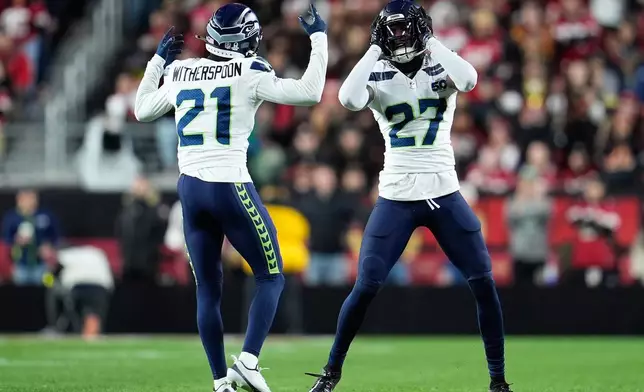 Seattle Seahawks cornerbacks Devon Witherspoon (21) and Riq Woolen (27) react after stopping the San Francisco 49ers on downs during the first half of an NFL football game in Santa Clara, Calif., Saturday, Jan. 3, 2026. (AP Photo/Godofredo A. Vásquez)