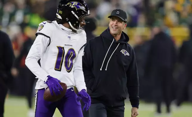 Baltimore Ravens wide receiver Deandre Hopkins (10) talks with head coach John Harbaugh, right, before an NFL football game against the Green Bay Packers, Saturday, Dec. 27, 2025, in Green Bay, Wis. (AP Photo/Matt Ludtke)