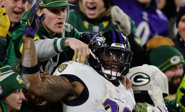 Baltimore Ravens running back Derrick Henry (22) celebrates in the stands after scoring a touchdown against the Green Bay Packers during the second half of an NFL football game, Saturday, Dec. 27, 2025, in Green Bay, Wis. (AP Photo/Matt Ludtke)