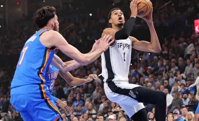 San Antonio Spurs forward Victor Wembanyama (1) moves to the basket near Oklahoma City Thunder center Chet Holmgren (7) during the first half of an NBA basketball game Tuesday, Jan. 13, 2026, in Oklahoma City. (AP Photo/Nate Billings)