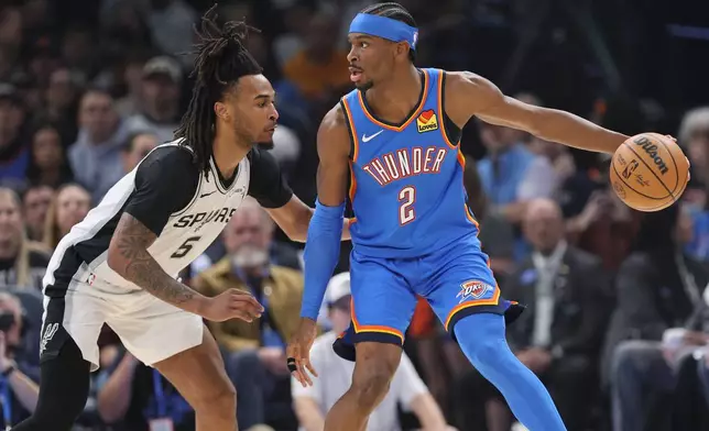 Oklahoma City Thunder guard Shai Gilgeous-Alexander (2) looks for an outlet against San Antonio Spurs guard Stephon Castle (5) during the first half of an NBA basketball game, Tuesday, Jan. 13, 2026, in Oklahoma City. (AP Photo/Nate Billings)