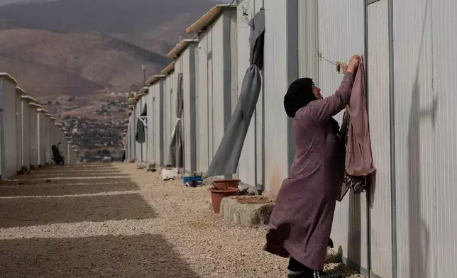 A Syrian Shiite woman, hangs her laundry at the Imam Ali Housing Compound, where hundreds of mostly Lebanese and Syrian Shiite Muslims displaced from Syria reside, in Hermel, northeast Lebanon, Friday, Jan. 30, 2026. (AP Photo/Hussein Malla)