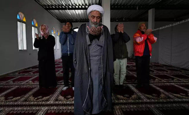 A Syrian Shiite cleric man, front, leads the noon prayer at the Imam Ali Housing Compound, where hundreds of mostly Lebanese and Syrian Shiite Muslims displaced from Syria reside, in Hermel, northeast Lebanon, Friday, Jan. 30, 2026. (AP Photo/Hussein Malla)