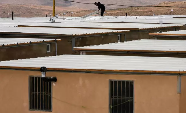 A Syrian Shiite man fixes the roof of his housing unit at the Imam Ali Housing Compound, where hundreds of mostly Lebanese and Syrian Shiite Muslims displaced from Syria reside, in Hermel, northeast Lebanon, Friday, Jan. 30, 2026. (AP Photo/Hussein Malla)