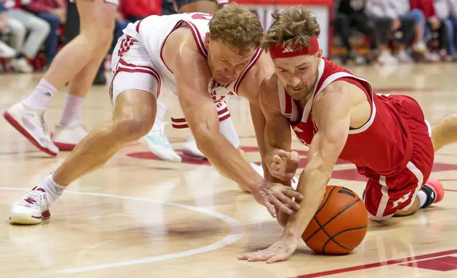 Nebraska guard Sam Hoiberg, right, goes after loose ball against Indiana forward Tucker DeVries during the first half of an NCAA college basketball game in Bloomington, Ind., Saturday, Jan. 10, 2026. (AP Photo/AJ Mast)