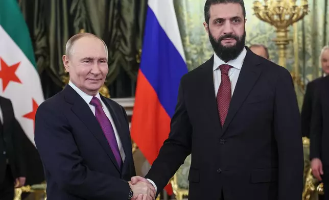 Russian President Vladimir Putin, left, and Syrian interim President Ahmad al-Sharaa pose for a photo during their meeting at the Grand Kremlin Palace in Moscow, on Wednesday, Jan. 28, 2026. (Maxim Shipenkov/Pool Photo via AP)