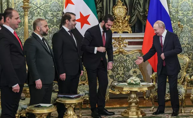 Russian President Vladimir Putin, right, welcomes Syrian interim President Ahmad al-Sharaa, center, for talks during their meeting at the Grand Kremlin Palace in Moscow, on Wednesday, Jan. 28, 2026. (Maxim Shipenkov/Pool Photo via AP)