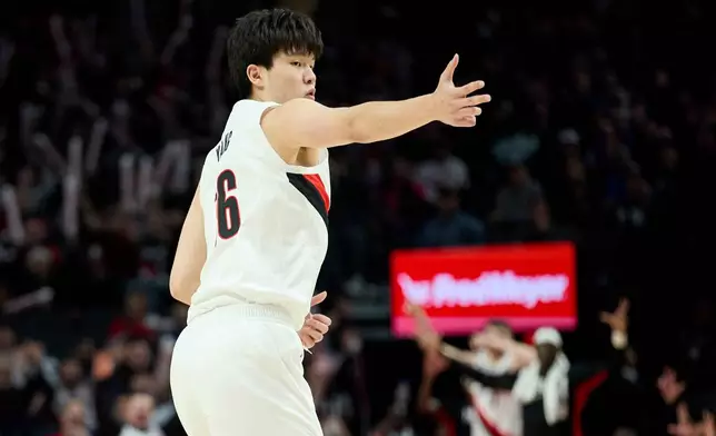 Portland Trail Blazers center Yang Hansen reacts after making a three-point basket against the Houston Rockets during the first half of an NBA basketball game in Portland, Ore., Wednesday, Jan. 7, 2026. (AP Photo/Craig Mitchelldyer)