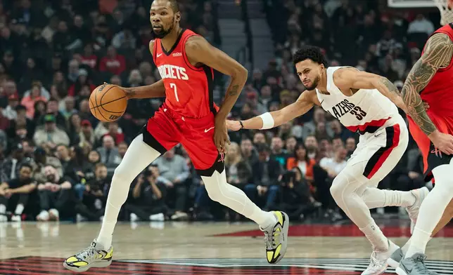 Houston Rockets forward Kevin Durant, left, dribbles around Portland Trail Blazers forward Toumani Camara during the first half of an NBA basketball game in Portland, Ore., Wednesday, Jan. 7, 2026. (AP Photo/Craig Mitchelldyer)