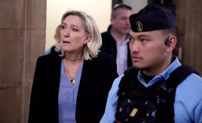 Far-right leader Marine Le Pen, left, walks outside the courtroom during a short break in her appeals trial in Paris, Tuesday, Jan. 20, 2026. (AP Photo/Michel Euler)