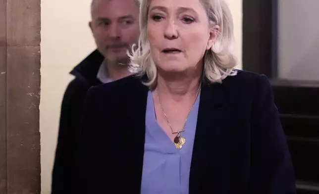 Far-right leader Marine Le Pen, right, walks outside the courtroom during a short break in her appeals trial in Paris, Tuesday, Jan. 20, 2026. (AP Photo/Michel Euler)