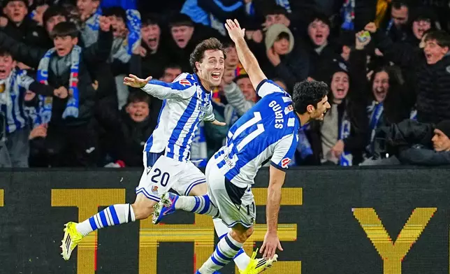 Real Sociedad's Goncalo Guedes, right, celebrates with Real Sociedad's Alvaro Odriozola after scoring his side's second goal during the Spanish La Liga soccer match between Real Sociedad and Barcelona in San Sebastian, Spain, Sunday, Jan. 18, 2026. (AP Photo/Miguel Oses)