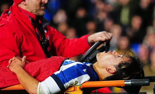 Real Sociedad's Takefusa Kubo is transported off the pitch during the Spanish La Liga soccer match between Real Sociedad and Barcelona in San Sebastian, Spain, Sunday, Jan. 18, 2026. (AP Photo/Miguel Oses)
