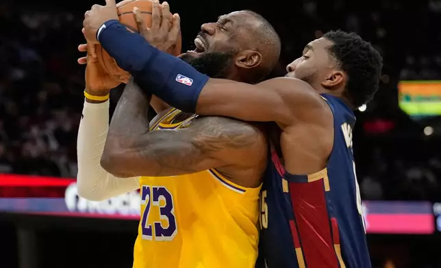 Los Angeles Lakers forward LeBron James (23) is fouled by Cleveland Cavaliers guard Donovan Mitchell, right, in the second half of an NBA basketball game in Cleveland, Wednesday, Jan. 28, 2026. (AP Photo/Sue Ogrocki)