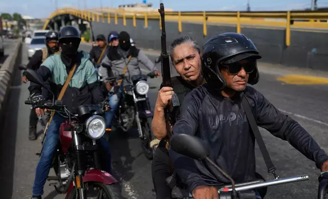 Pro-government armed civilians patrol in La Guaira, Venezuela, Saturday, Jan. 3, 2026, after U.S. President Donald Trump announced that President Nicolás Maduro had been captured and flown out of the country. (AP Photo/Matias Delacroix)