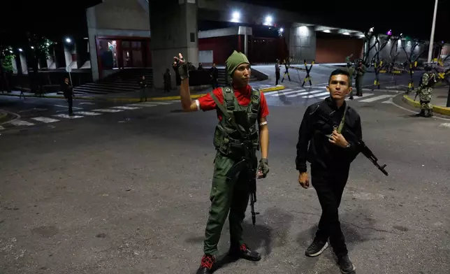 Members of the presidential guard stand outside the Miraflores presidential palace after explosions and low-flying aircraft were heard in Caracas, Venezuela, Saturday, Jan. 3, 2026. (AP Photo/Cristian Hernandez)