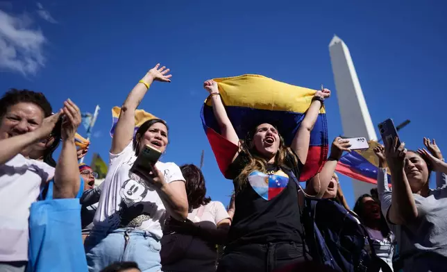 Venezuelans celebrate at the Obelisk in Buenos Aires, Argentina, Saturday, Jan. 3, 2026, after U.S. President Donald Trump announced that President Nicolas Maduro had been captured and flown out of Venezuela. (AP Photo/Natacha Pisarenko)