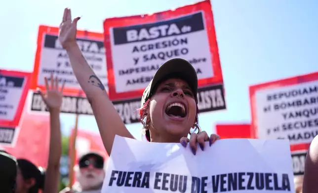 A demonstrator holds a banner with a message that reads in Spanish: "Out of Venezuela, U.S." during a protest outside the U.S embassy after President Donald Trump announced that Venezuelan President Nicolas Maduro had been captured, in Buenos Aires, Argentina, Saturday, Jan. 3, 2026. (AP Photo/Natacha Pisarenko)