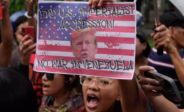 Protesters shout slogans while holding a picture of U.S. President Donald Trump as they denounce the U.S. government and Trump after the U.S. captured Venezuelan President Nicolas Maduro during a rally near the U.S. Embassy in Manila, Philippines on Monday, Jan. 5, 2026. (AP Photo/Aaron Favila)