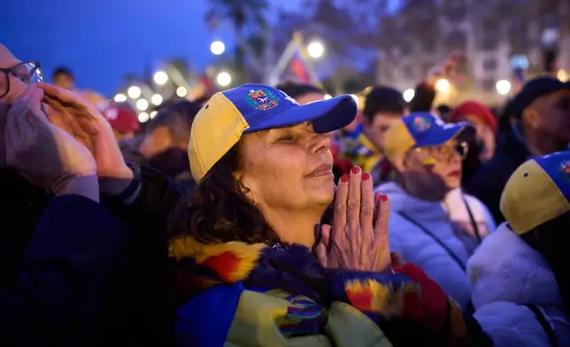 A woman reacts as people gather against Venezuelan President Nicolás Maduro in downtown Barcelona, Spain, Sunday, Jan. 4, 2026. (AP Photo/Emilio Morenatti)