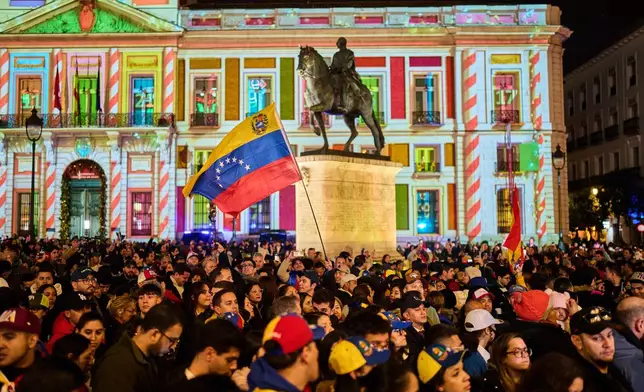 Venezuelans celebrate in Madrid, Saturday, Jan. 3, 2026, after U.S. President Donald Trump announced that President Nicolás Maduro had been captured and flown out of Venezuela. (AP Photo/Bernat Armangue)
