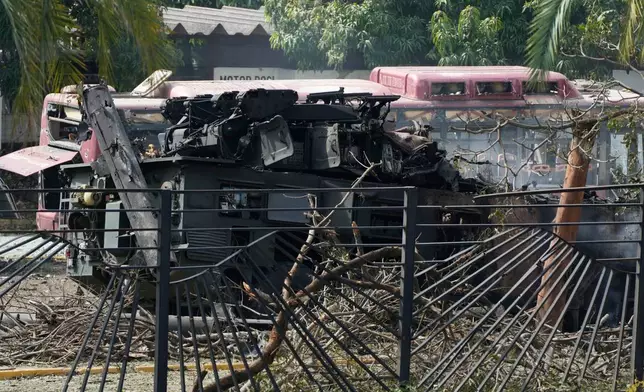 A destroyed armored vehicle sits at La Carlota airport in Caracas, Venezuela, Saturday, Jan. 3, 2026, after explosions were reported at the site. (AP Photo/Ariana Cubillos)
