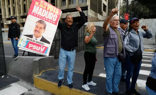 Supporters display a poster of Venezuelan President Nicolás Maduro in Caracas, Venezuela, Saturday, Jan. 3, 2026, after U.S. President Donald Trump announced Maduro had been captured and flown out of the country. (AP Photo/Cristian Hernandez)