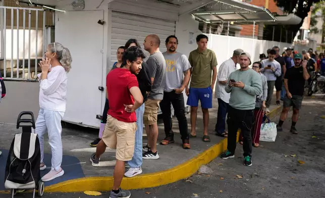 People line up outside a supermarket in Caracas, Venezuela, Saturday, Jan. 3, 2026, after U.S. President Donald Trump announced that President Nicolás Maduro had been captured and flown out of the country. (AP Photo/Ariana Cubillos)