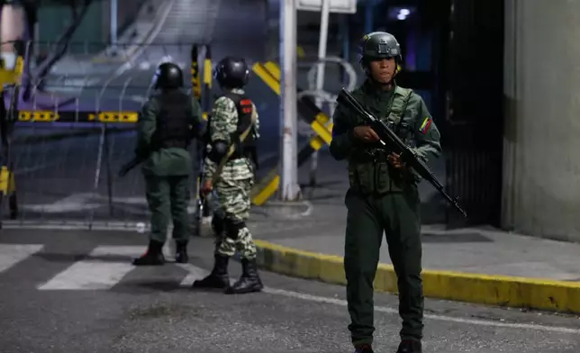 Soldiers guard the area around the Miraflores presidential palace after explosions and low-flying aircraft were heard in Caracas, Venezuela, Saturday, Jan. 3, 2026. (AP Photo/Cristian Hernandez)