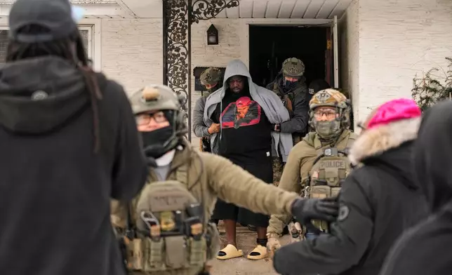 A man is arrested by federal immigration officers Sunday, Jan. 11, 2026, in Minneapolis. (AP Photo/John Locher)